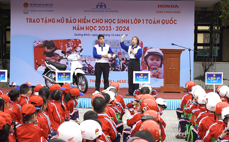 Hướng dẫn học sinh đội mũ bảo hiểm đúng cách.