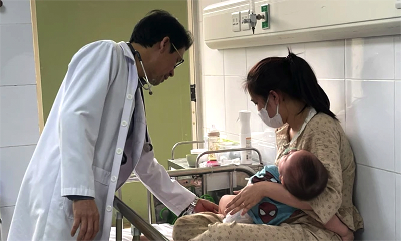 Bác sĩ khám cho bệnh nhi nằm viện do mắc sởi. (Ảnh: HẢI NGÔ)
