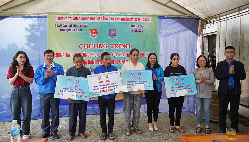 Đại diện lãnh đạo Đảng ủy, Đoàn CCQ Đảng tỉnh, Ủy ban MTTQVN huyện Minh Hóa trao biển hỗ trợ cho các gia đình xóa nhà tạm, nhà dột nát.