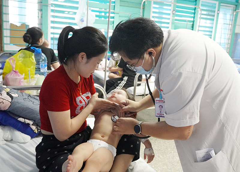 Bác sĩ thăm khám cho bệnh nhi đang điều trị bệnh sởi.