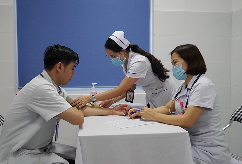 Bác sĩ tiến hành khám sàng lọc trước khi tiêm phòng vắc-xin sởi cho nhân viên y tế.