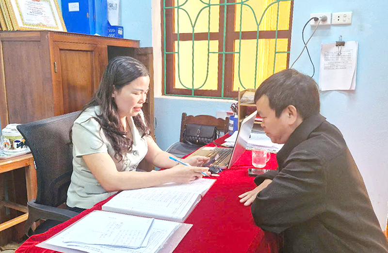Chị Hà Thị Hoa đang tư vấn BHYT cho người dân xã Mai Hóa.