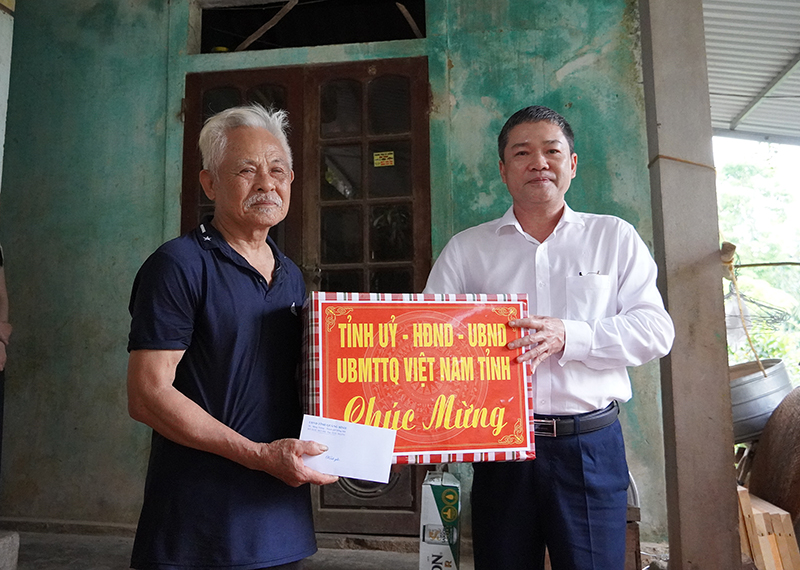 Đồng chí Phó Chủ tịch UBND tỉnh Phan Phong Phú tặng quà cho ông Hà Huy Điệt.