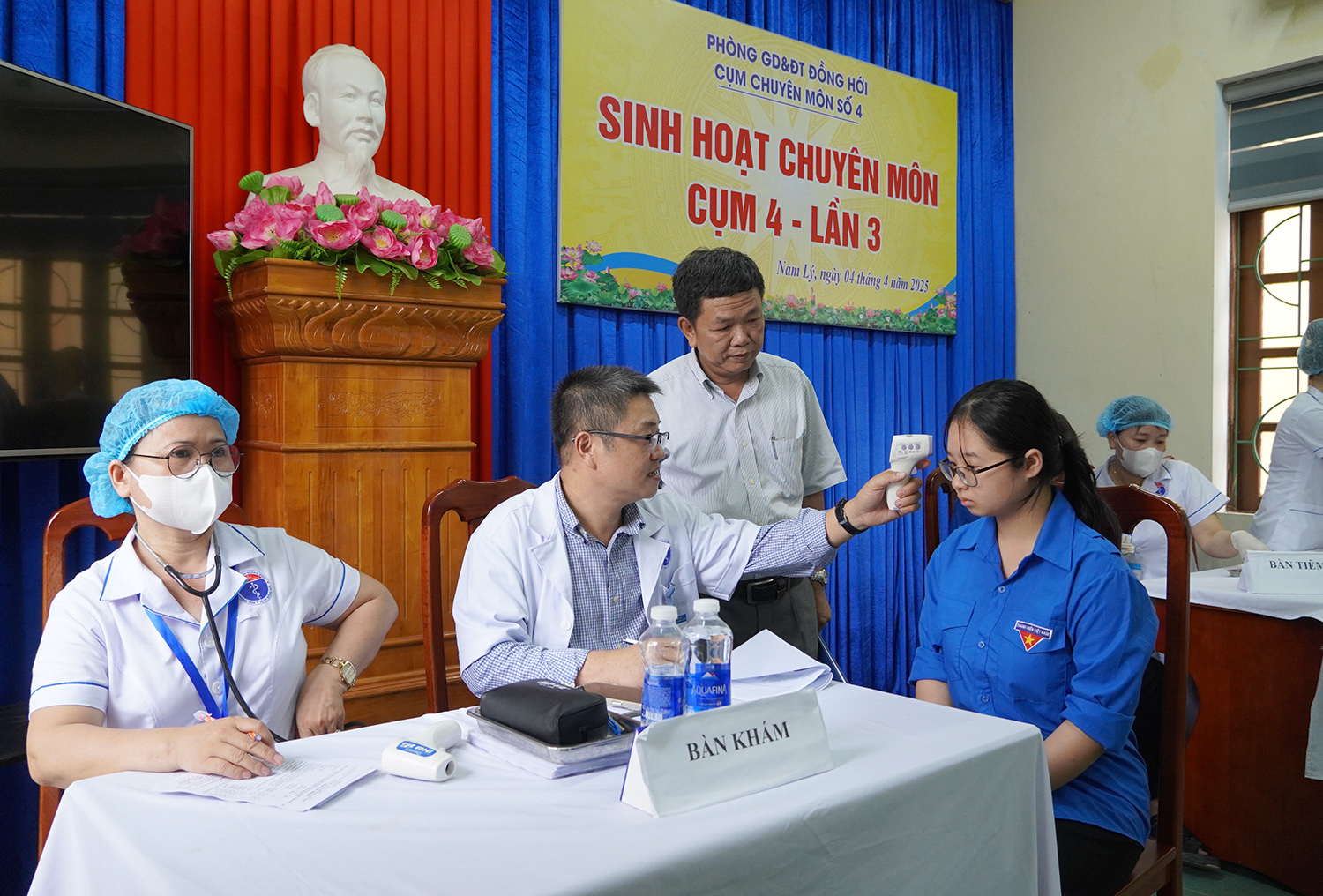 Bác sĩ khám sàng lọc trước khi tiêm vắc-xin phòng ngừa sởi cho học sinh.