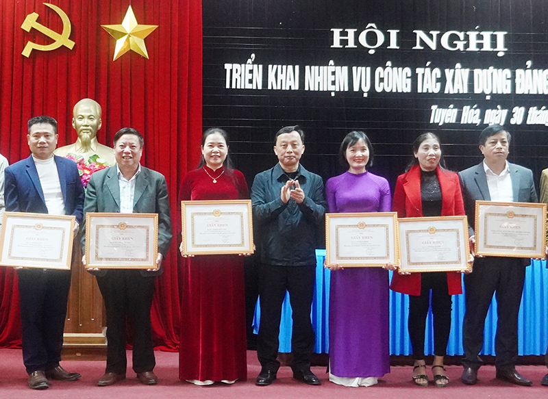 Bí thư Chi bộ, Hiệu trưởng Trường THCS Kim Hóa Phạm Minh Tâm (ngoài cùng bên phải) nhận giấy khen của Ban Thường vụ Huyện ủy Tuyên Hóa về thành tích  