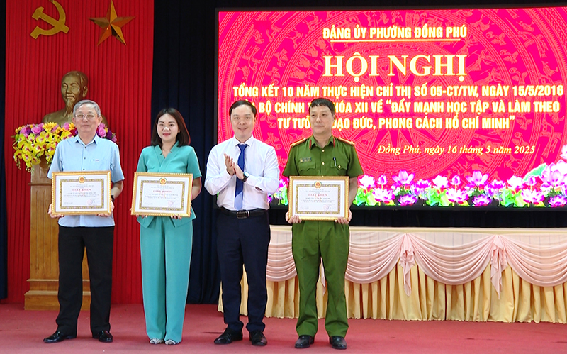 Bí thư Đảng ủy phường Đồng Phú Hà Quốc Vương Anh trao thưởng cho các tập thể.