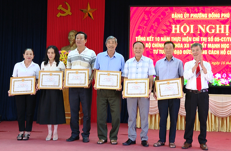 Đại diện Đảng ủy phường Đồng Phú trao giấy khen cho các cá nhân.