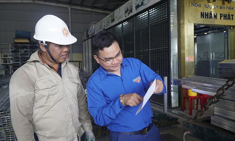 Doanh nhân trẻ Trần Văn Tuấn trao đổi công việc với công nhân tại xưởng sản xuất.