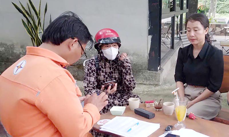 Nhân viên Điện lực Lệ Thủy hướng dẫn khách hàng thực hiện cài đặt app và thực hiện chuyển đổi số.