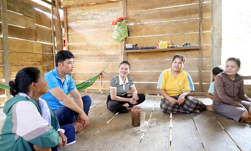 Cao Thị Vân (áo sọc ngang) trò chuyện cùng các hộ dân trong bản.