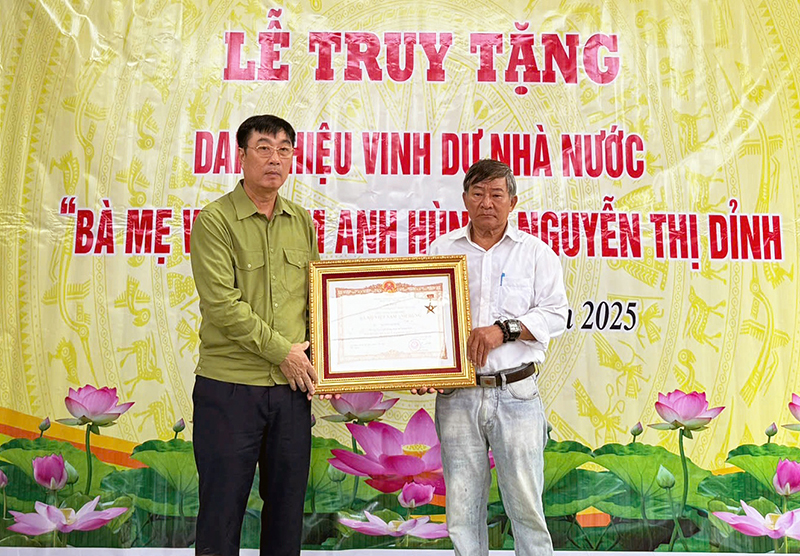 Đại diện lãnh đạo huyện Quảng Ninh trao danh hiệu “Bà mẹ Việt Nam anh hùng” cho thân nhân mẹ Nguyễn Thị Dỉnh.