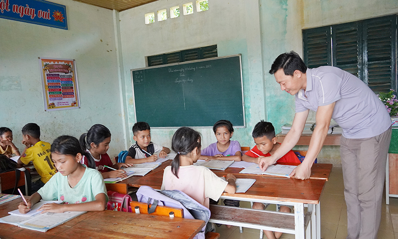 Thầy giáo Đinh Văn Chung đang dạy các em học sinh lớp ghép tại bản Cha Cáp.