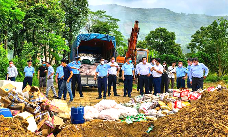 Lực lượng chức năng tỉnh Lào Cai tổ chức tiêu hủy hàng kém chất lượng và hàng hóa không rõ nguồn gốc xuất xứ. Ảnh: TTXVN phát
