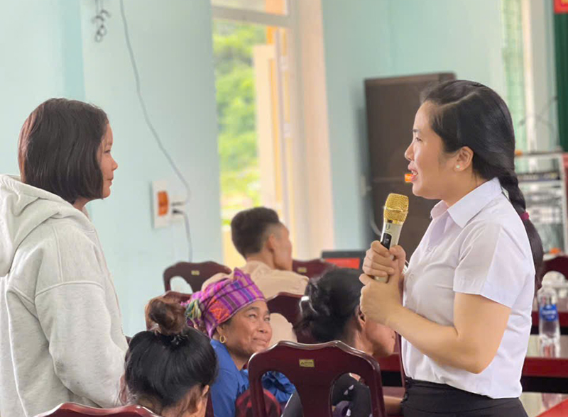 Cán bộ trợ giúp pháp lý trao đổi với người dân tại hội nghị tuyên truyền pháp luật.